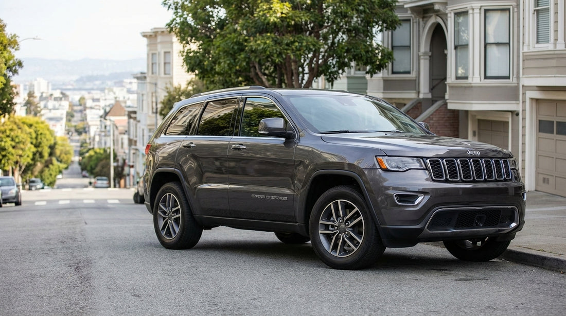 A silver car hire parked on a steep San Francisco hill with its wheels turned to the curb