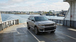 A car hire vehicle on a ferry sailing past the Statue of Liberty with the sunny New York City skyline in the background