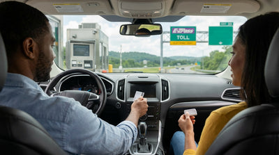 A silver rental car driving on a highway through the rolling green hills of Pennsylvania on a sunny day