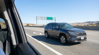 A car hire drives on the multi-lane Bay Bridge with the San Francisco skyline in the background