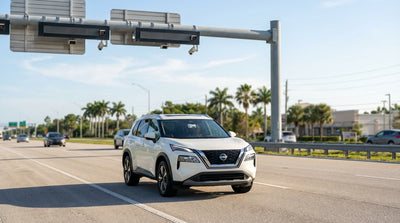 A white car rental driving on a highway over the water in sunny Florida