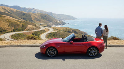A car rental drives across the iconic Golden Gate Bridge on a sunny day in San Francisco