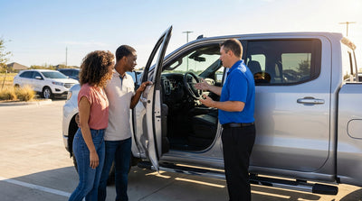 Close-up of a hand on an automatic gear shift in a car rental with a sunny Texas road visible through the windshield
