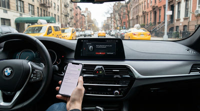 A person looking at their smartphone in the driver's seat of a car rental on a New York City street