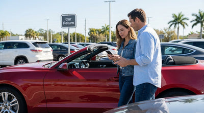 A row of various models of sedans and SUVs in a sunny US car hire lot at an airport