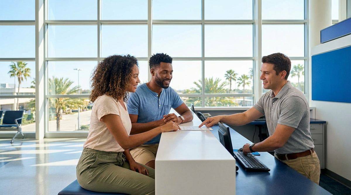 A person smiles while holding the keys to their car rental on a sunny street in Orlando