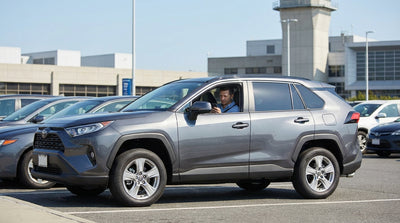 A driver waits in a car hire at the cell phone lot, watching planes land at LaGuardia Airport in New York