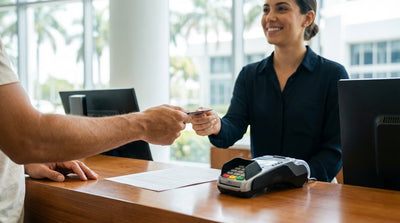 A red convertible for car rental parked on a sunny street in Miami with palm trees lining the sidewalk