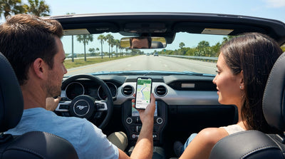 A person adjusts a smartphone navigation app in a car rental on a sunny Florida road