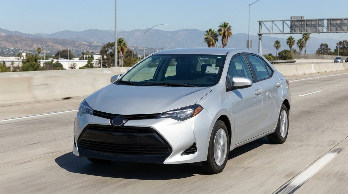 A modern car rental driving on a sunny Los Angeles freeway with the downtown skyline in the distance