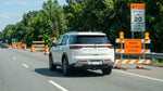 A car hire drives through a highway work zone with orange safety cones and speed limit signs in Pennsylvania