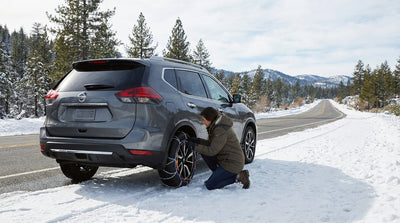 A car rental driving on a snow-covered road through the scenic Sierra Nevada mountains in California