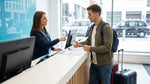 Customer presenting a driving licence to an agent at a car rental counter in New York