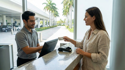 A stylish convertible car rental parked on a sunny street lined with palm trees in South Beach, Miami