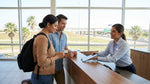 A man hands over his license to an agent at a car hire counter in a modern Texas airport