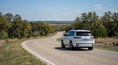 A car hire vehicle drives down a sunny multi-lane highway surrounded by the Texas landscape