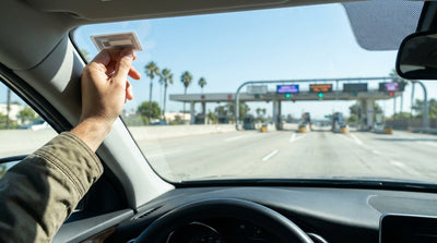 Driver's view from a car rental looking out at a sunny, palm-tree-lined highway in southern California