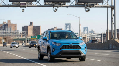 View from a car hire on a New York highway approaching a large overhead E-ZPass toll sign