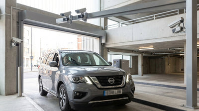 A driver in a car hire waits at the ANPR entry barrier of a multi-level parking garage in San Francisco