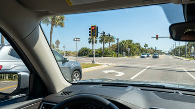 A car hire waiting at a red traffic light on a sunny one-way street in Florida
