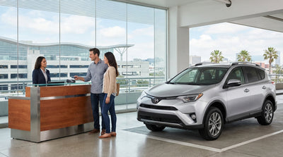 A modern car rental parked on a hill with the San Francisco Golden Gate Bridge in the background