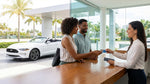 A white convertible car rental parked on a sunny street with palm trees in Miami