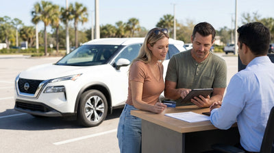 A person uses a credit card to pay for their car rental at a sunlit service desk in Miami