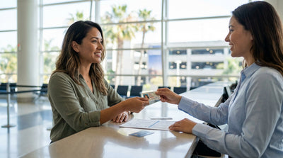 A person presents their driver's license at a car hire counter to collect car keys in California