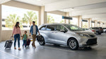 Travelers at a car hire counter inside the busy Orlando Airport terminal picking up their vehicle keys