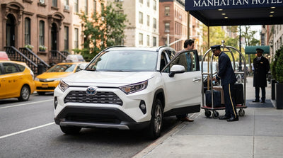 A car hire vehicle briefly stopped on a bustling Manhattan street in New York City, near a hotel entrance