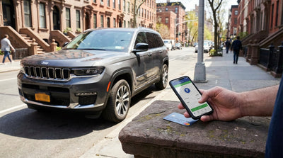 A silver car hire parked on a bustling New York street with yellow cabs and skyscrapers in the background