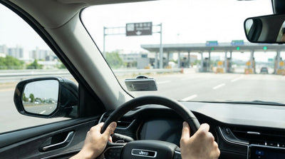 A car hire driving over a large bridge towards the New York City skyline on a clear day