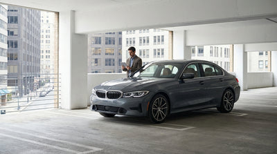 A car rental drives through the busy, neon-lit streets of Times Square in New York City at night
