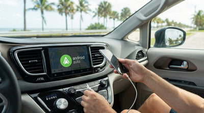A person plugs a phone into the USB port of a car rental dashboard on a sunny day in Florida