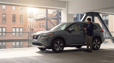 A car rental driving across the Brooklyn Bridge with the New York City skyline in the background