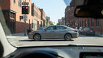 A car hire vehicle stopped at a red traffic light on a one-way street with historic buildings in Philadelphia, Pennsylvania