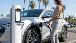 Electric car rental plugged into a roadside charging station on a sunny day in California