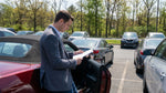 White car rental driving past autumn foliage on a scenic highway in Pennsylvania