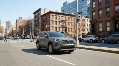 A car hire driving on a busy New York street with a school zone speed limit sign visible