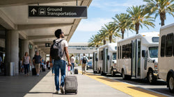 Passengers with luggage waiting for a car rental shuttle bus outside Terminal 5 at Los Angeles airport