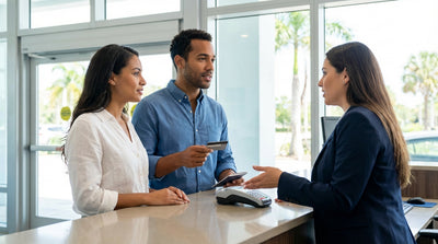 A convertible car rental driving along a scenic, palm-lined coastal road in Florida