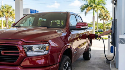 A white convertible car hire driving on a palm-tree-lined highway under a sunny blue sky in Florida