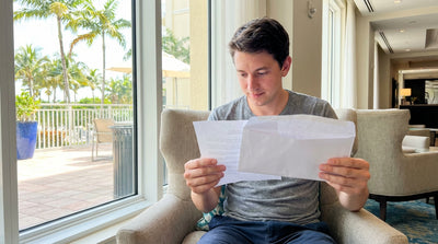 A white car rental driving under an electronic toll gantry on a sunny multi-lane highway in Florida