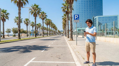 A tow truck hooks up a white car hire on a sunny street in Miami with palm trees