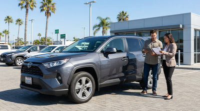 A sedan from a car hire service driving along the sunny Pacific Coast Highway in California