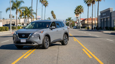 A driver in a car rental uses the center turn lane on a sunny, palm-lined street in California