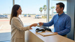A traveler uses a credit card to pay for their car hire at a rental desk in a Texas airport