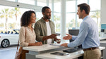 Two people discussing their car hire agreement with a rental agent at a desk in Orlando