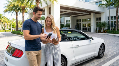A red convertible car hire driving along a scenic coastal road in Florida lined with palm trees