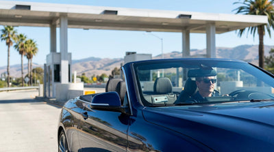 A car hire driving across the Golden Gate Bridge on a sunny day in California